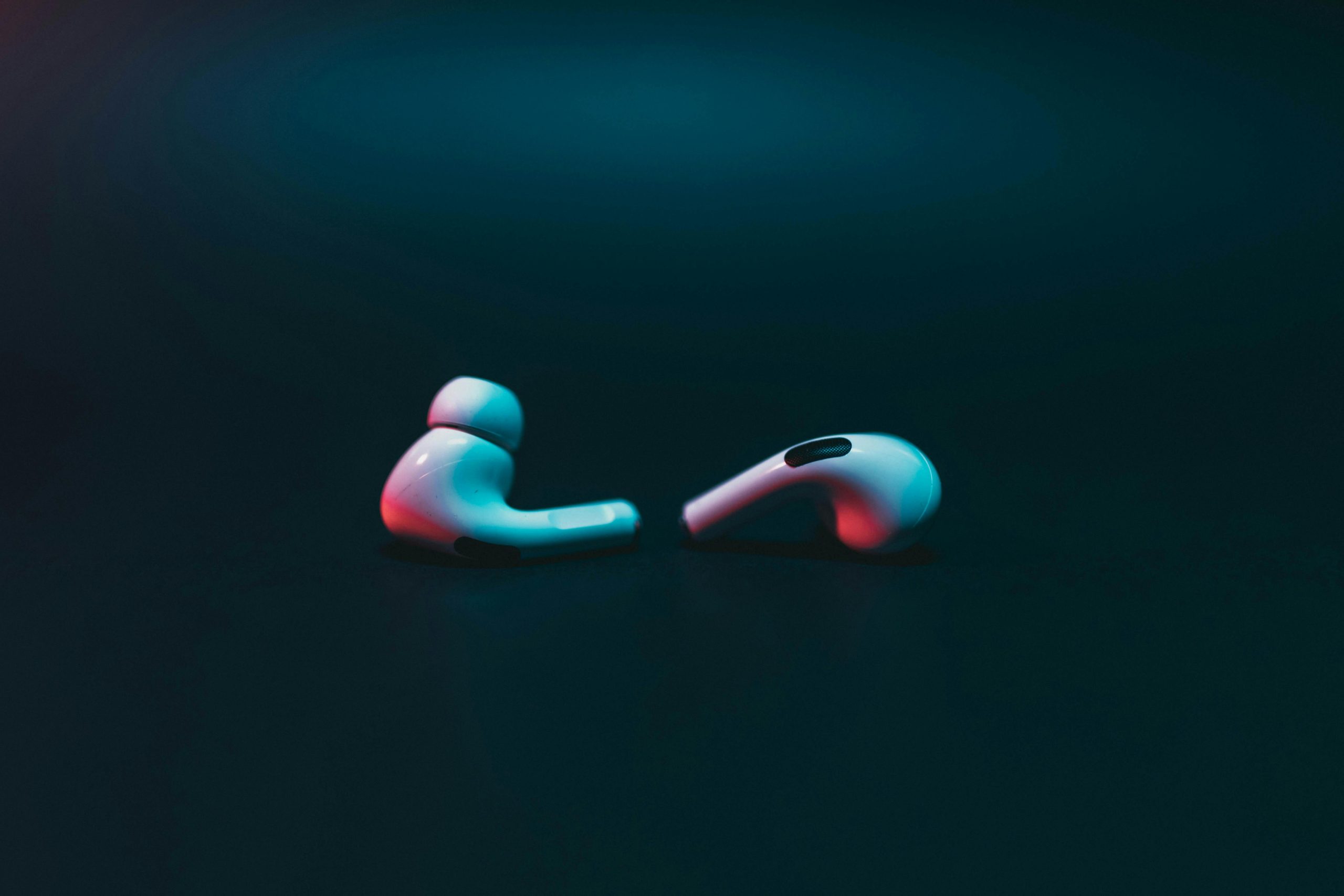 Close-up of wireless earphones on a moody dark backdrop. Ideal for tech themes.
